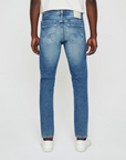 model facing sideways wearing ag jeans dylan slim fit jean in talavera blue, shown from the rear