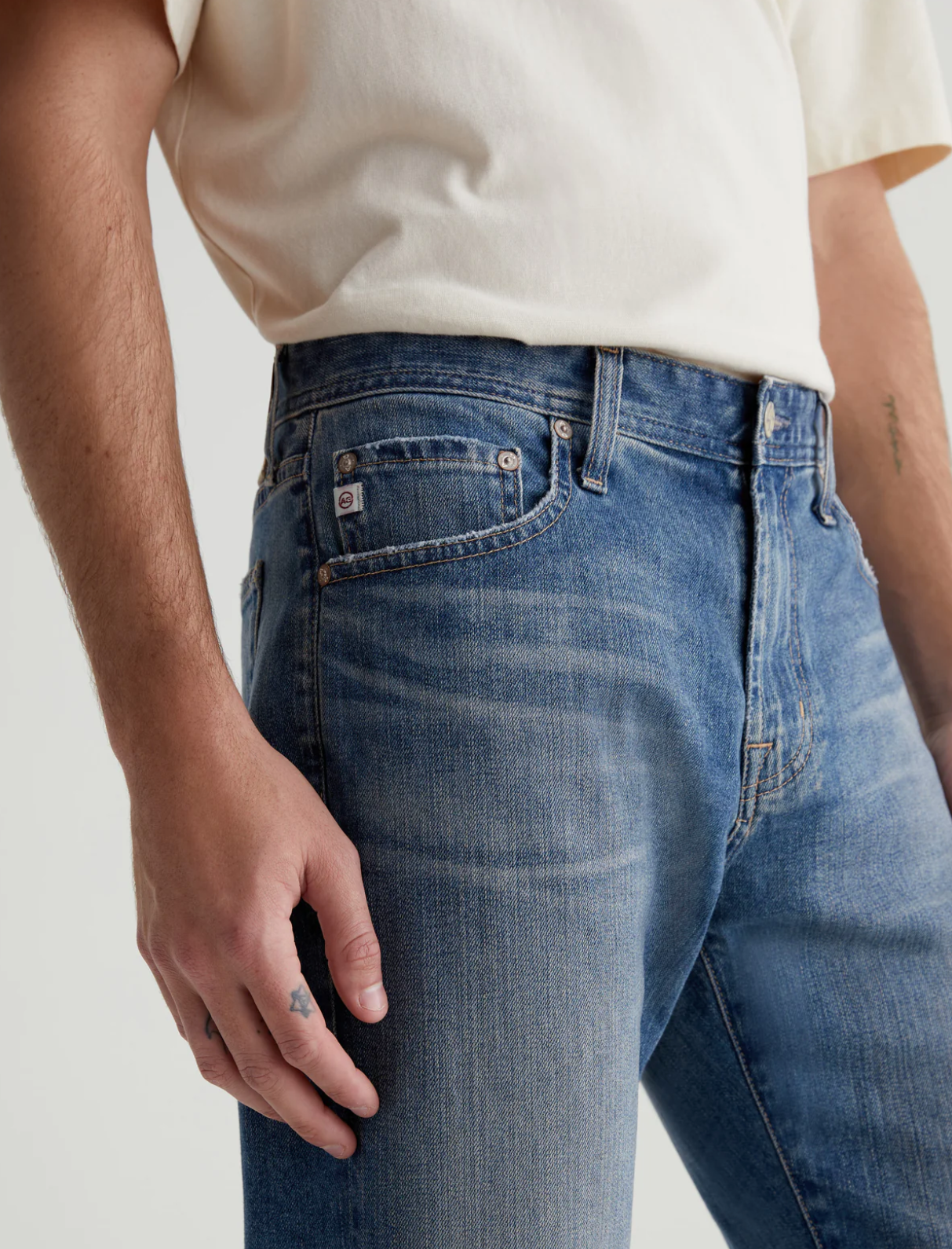 close up view of the rear of the ag jeans tellis modern slim jean in 16 years clifton blue, showing front pockets