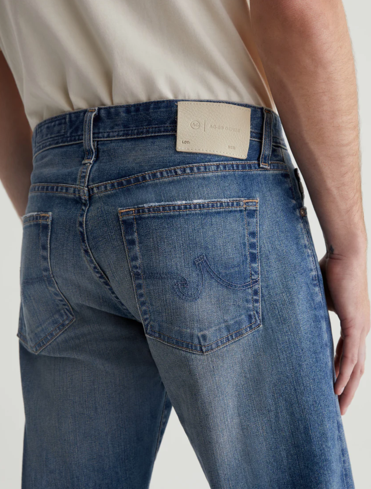 close up view of the rear of the ag jeans tellis modern slim jean in 16 years clifton blue, showing back pocket detail