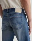 close up view of the rear of the ag jeans tellis modern slim jean in 16 years clifton blue, showing back pocket detail