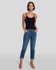 model posing, wearing 7 for all mankind josefina boyfriend fit jean in broken twill vanity blue, paired with a black tank top and sandals