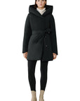 Woman wearing a black coat with a hood on a white background