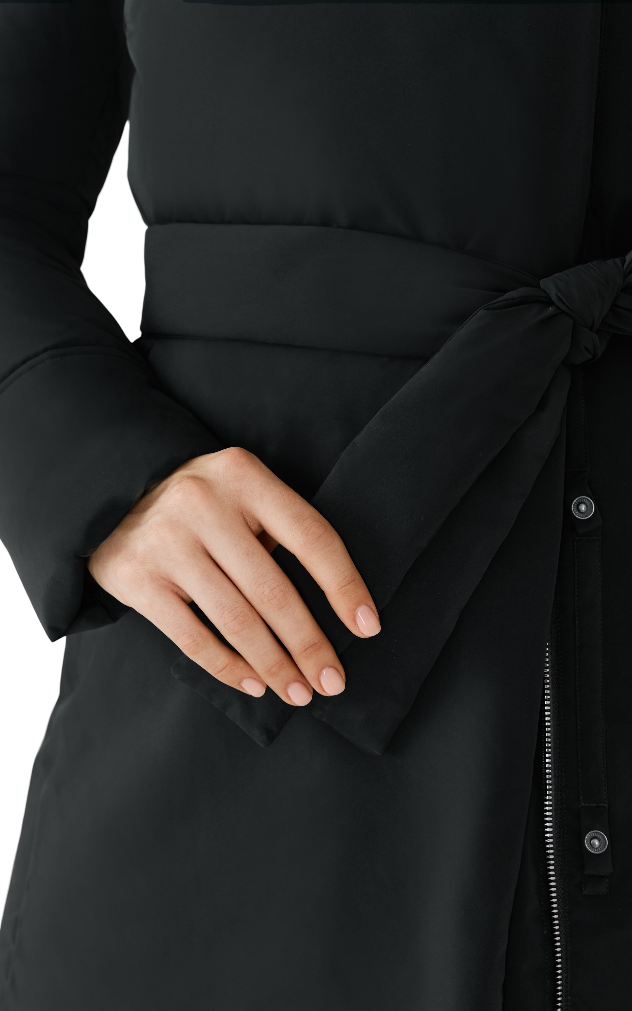 Close-up of a person wearing a black puffer coat with a tied belt.