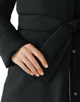 Close-up of a person wearing a black puffer coat with a tied belt.