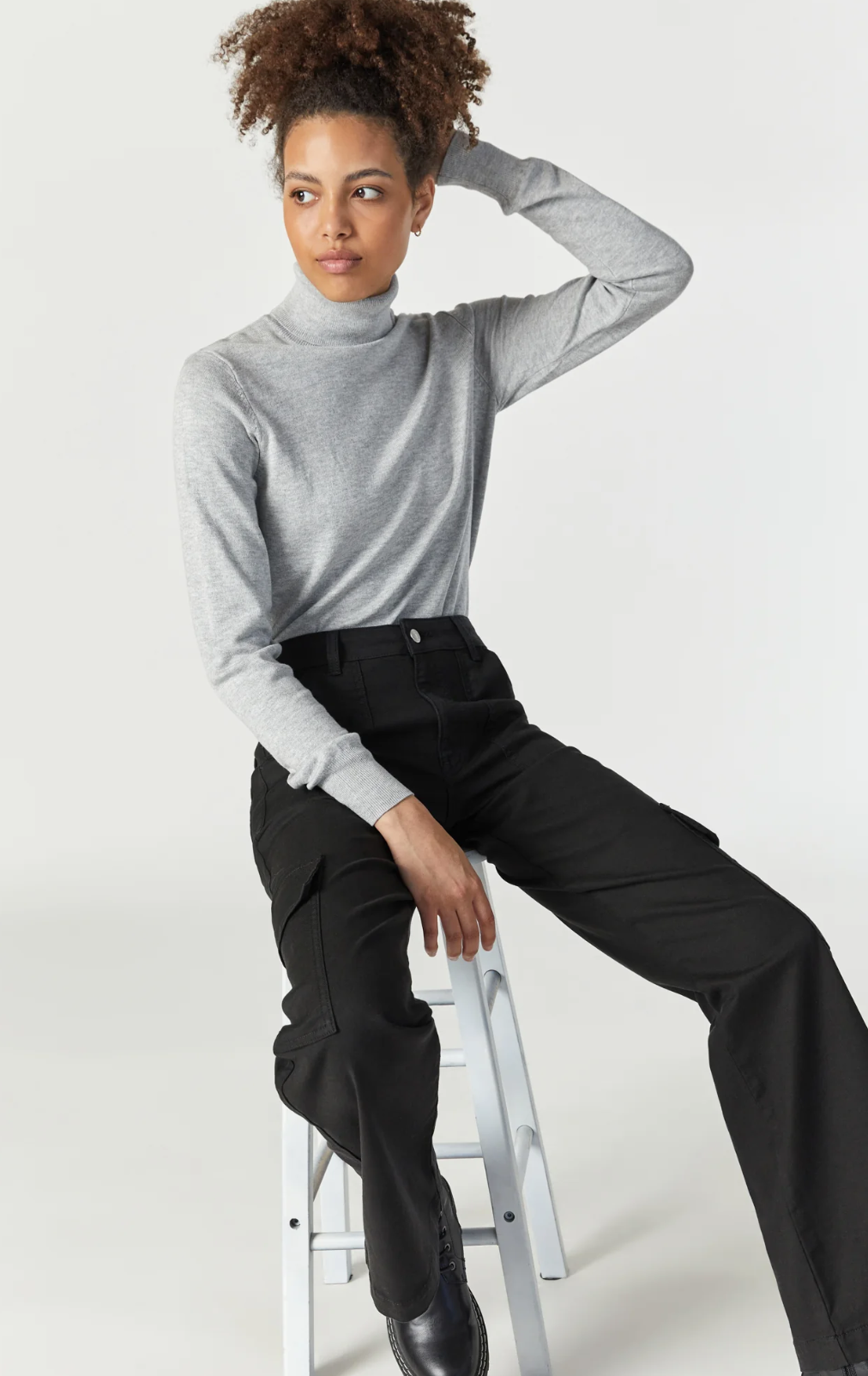 model seated, wearing mavi jeans alva cargo pant in black luxe twill