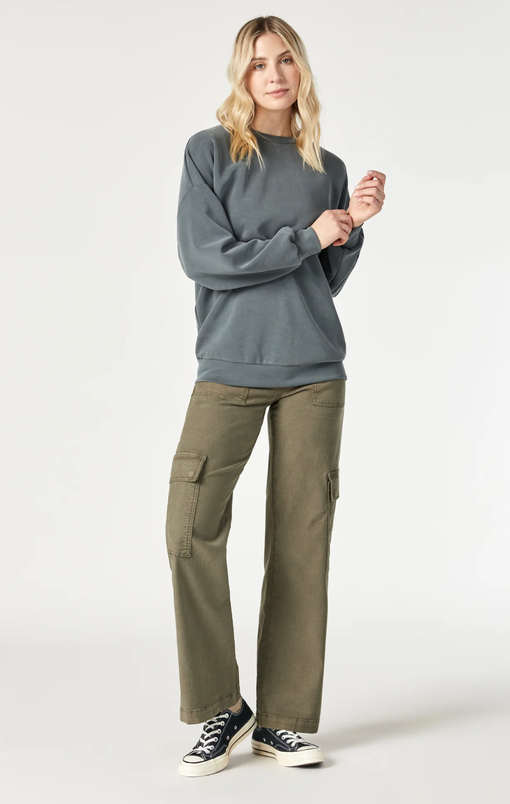 model wearing mavi jeans alva cargo pants in capers luxe twill, with grey sweatshirt