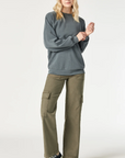 model wearing mavi jeans alva cargo pants in capers luxe twill, with grey sweatshirt