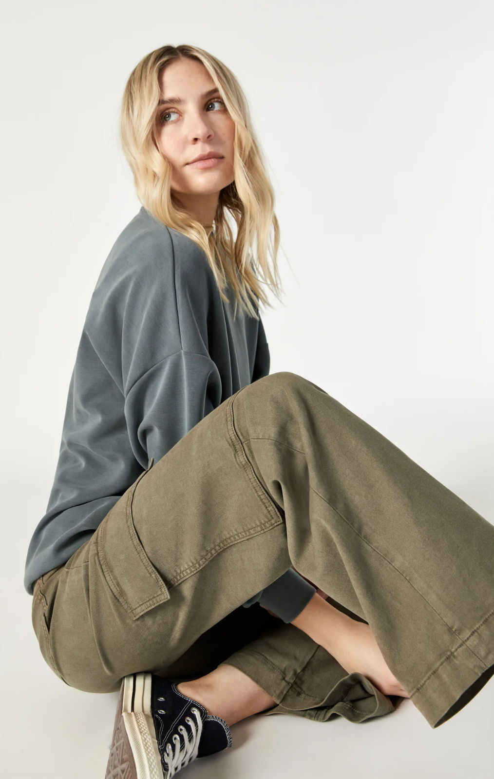 model sitting, wearing mavi jeans alva cargo pants in capers luxe twill