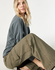 model sitting, wearing mavi jeans alva cargo pants in capers luxe twill