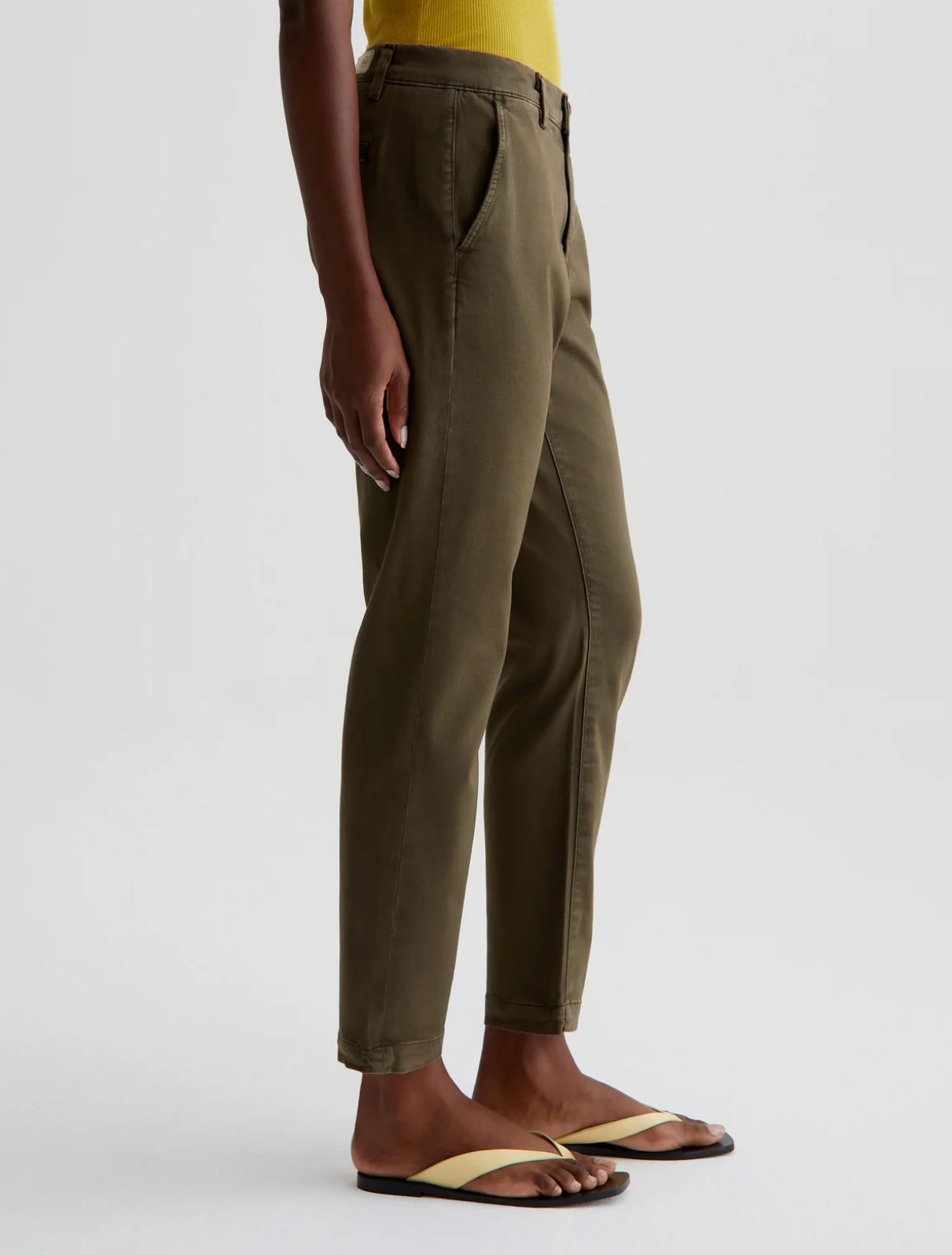 model facing to the side wearing caden tailored trouser in sulfur shady moss green, shown from the waist down