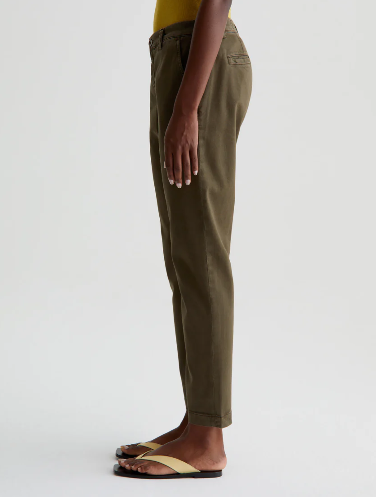 model facing left wearing caden tailored trouser in sulfur shady moss green, shown from the waist down