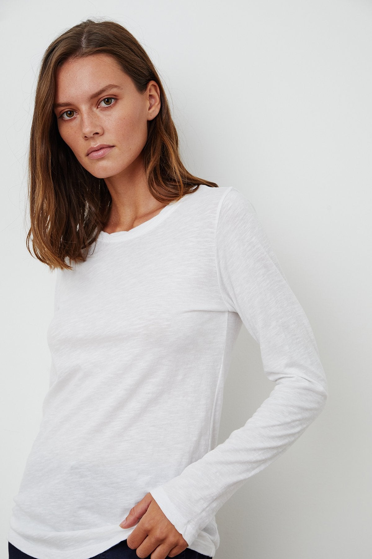 model wearing liz city slub crew neck long sleeve tee in white from Velvet, standing at an angle