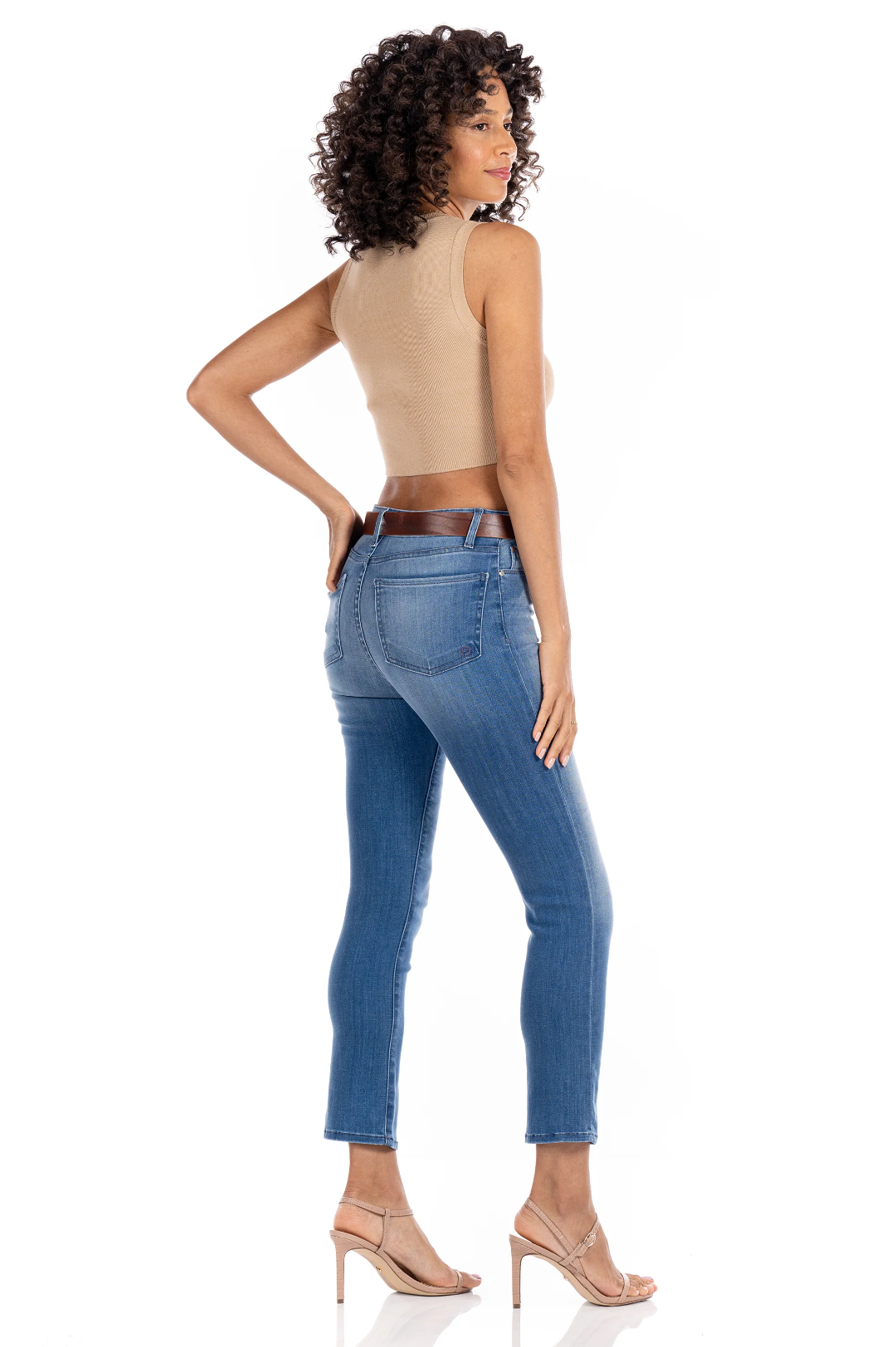 model wearing fidelity denim cher slim jean in st martin blue, shown from the rear and paired with beige tank top