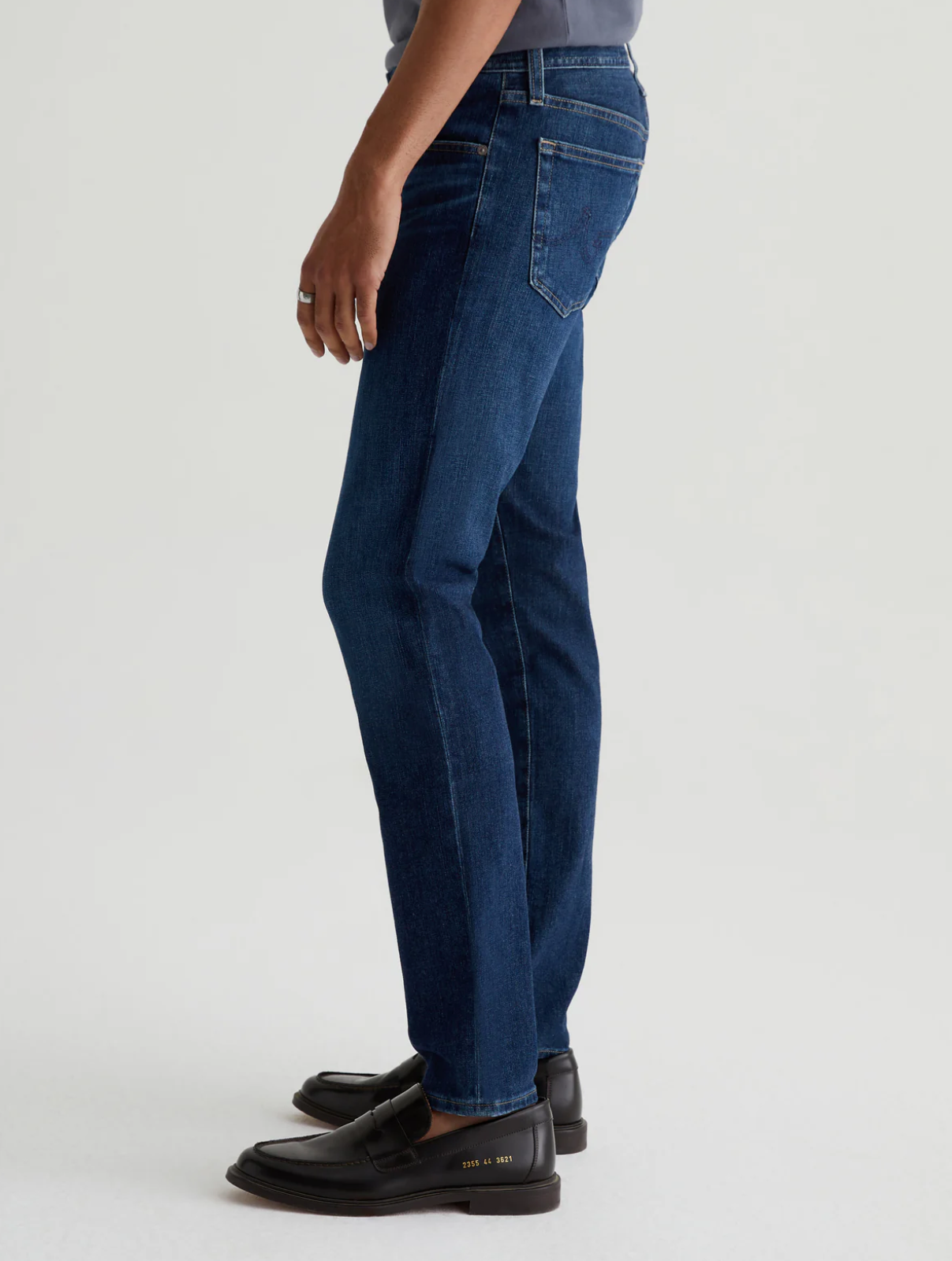 model facing sideways wearing the ag jeans dylan slim fit jean in midlands blue, shown from the waist down