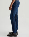 model facing sideways wearing the ag jeans dylan slim fit jean in midlands blue, shown from the waist down