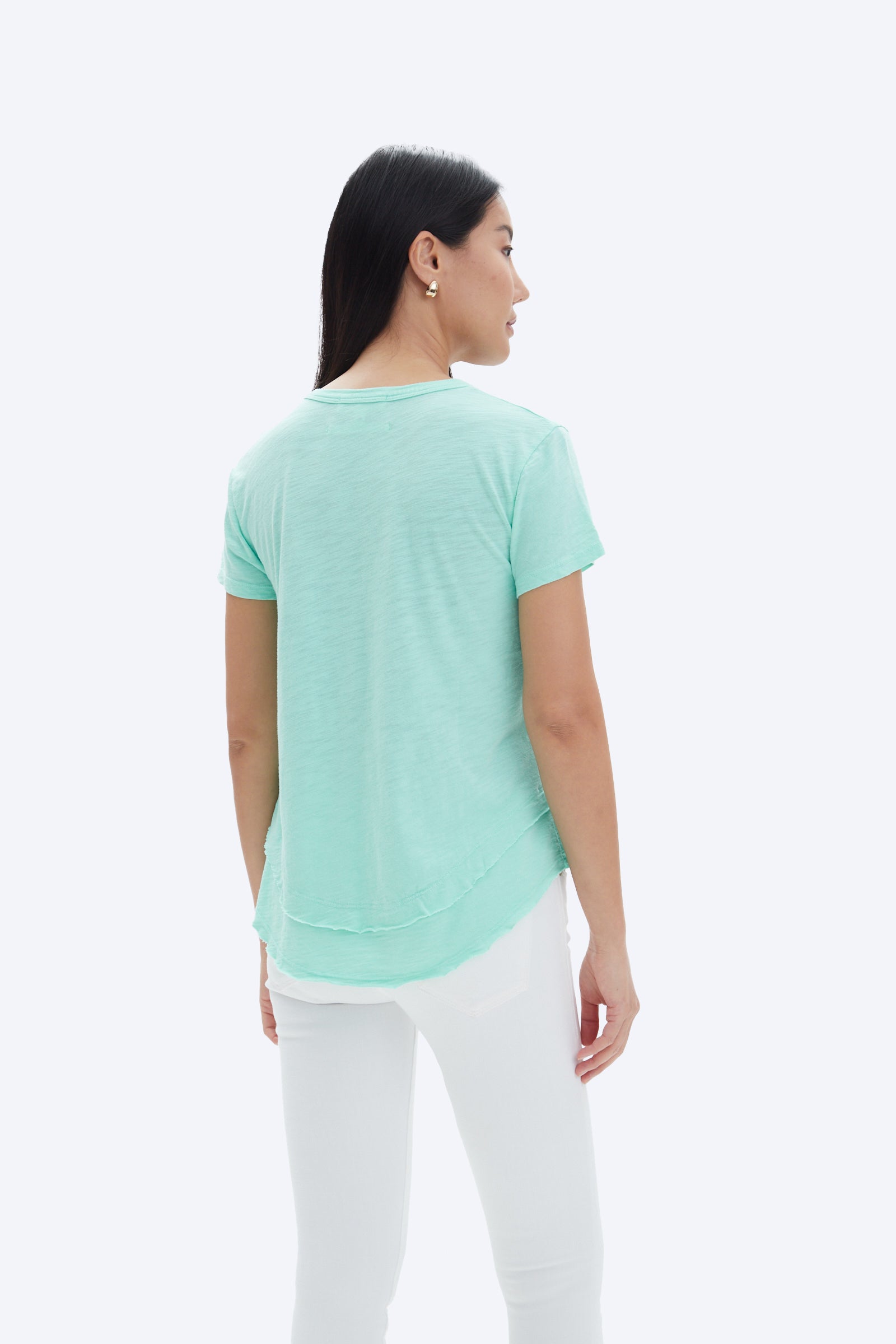 model wearing chrldr ava mock layer t shirt in light green, shown from the back