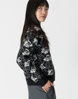 model wearing jordyn rose print crew neck sweater from lyla & luxe, side view