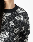 model wearing jordyn rose print crew neck sweater from lyla & luxe, detail view