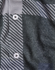 close up of a grey shirt with large exaggerated plaid print