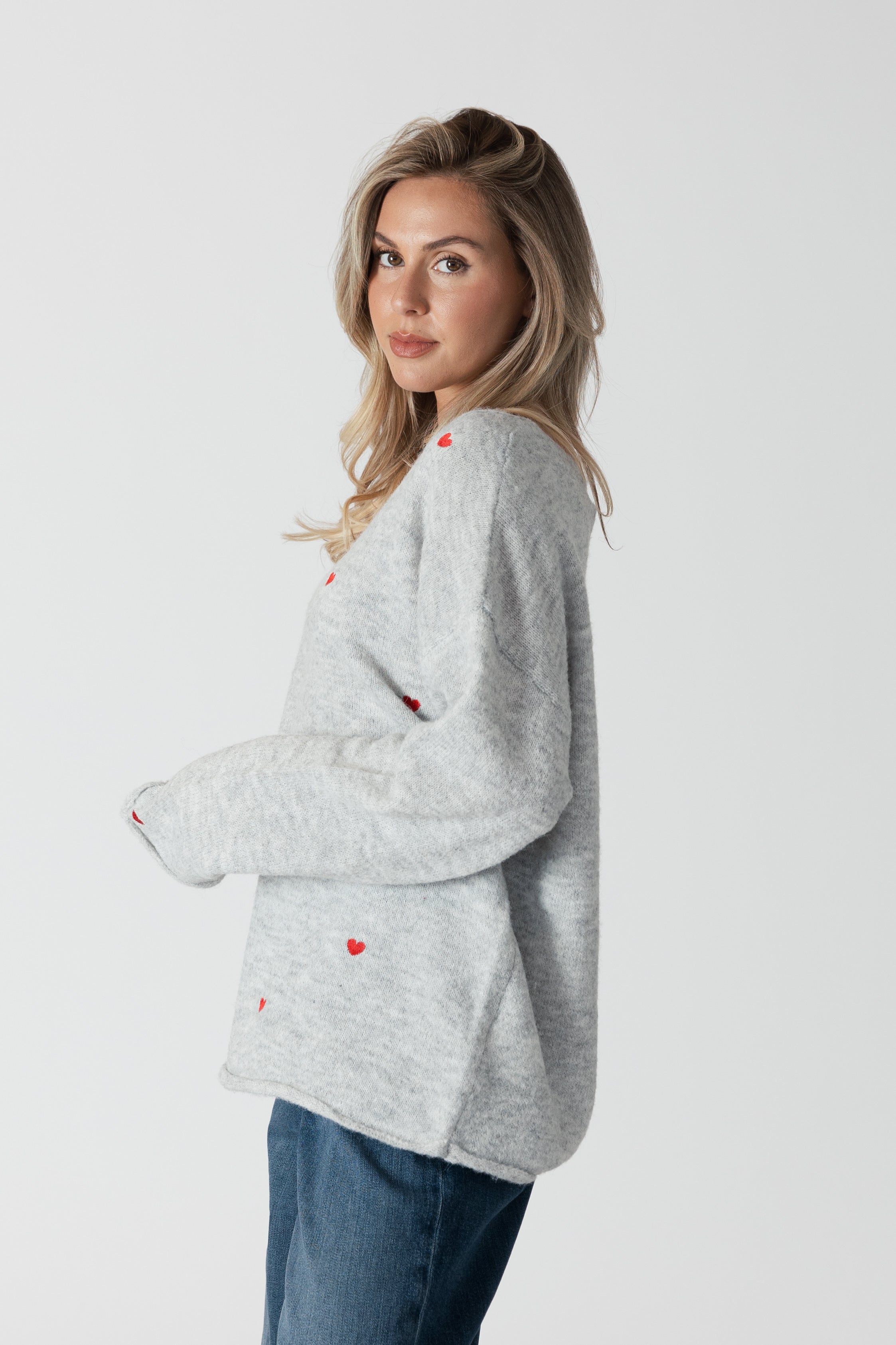 model wearing lyla &amp; luxe luna v-neck embroidered hearts sweater, side view