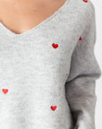 model wearing lyla & luxe luna v-neck embroidered hearts sweater, close up of embroidery