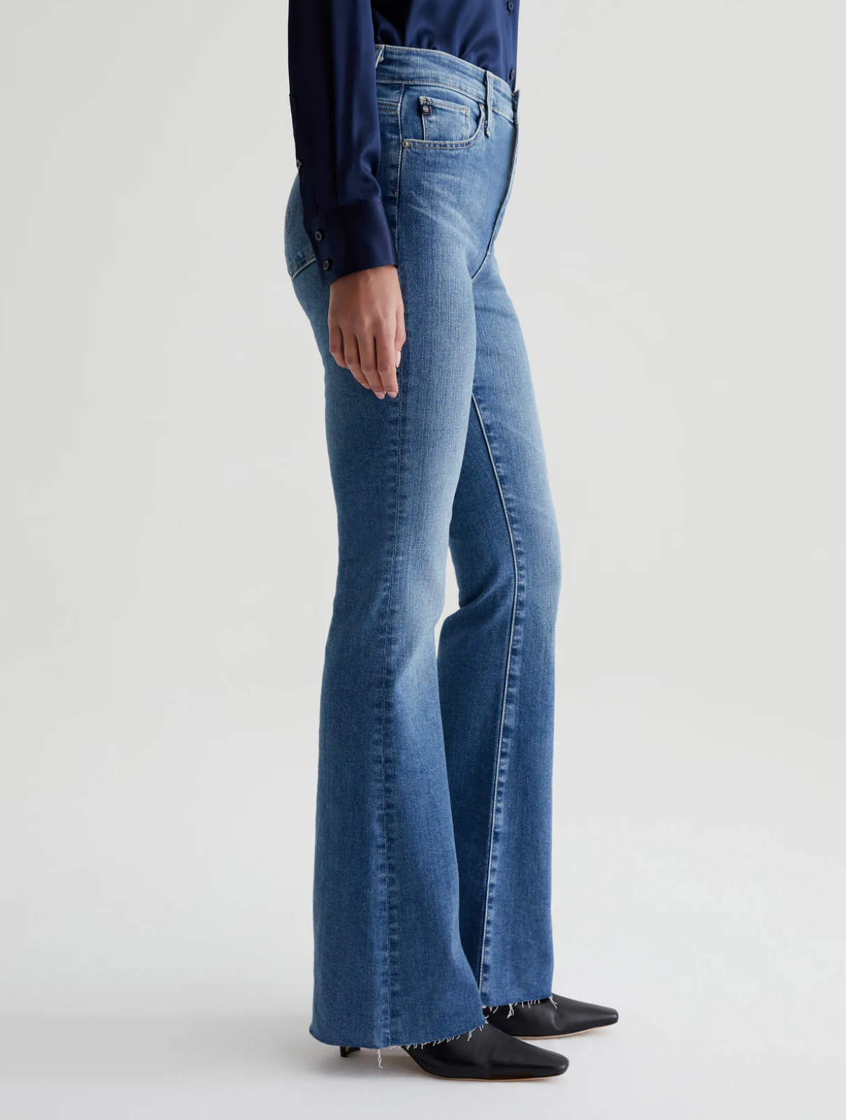 model wearing ag jeans farrah boot cut jean in montecito blue, shown from the side