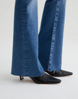 close up of the hem of ag jeans farrah boot cut jean in montecito blue, showing raw hem detail