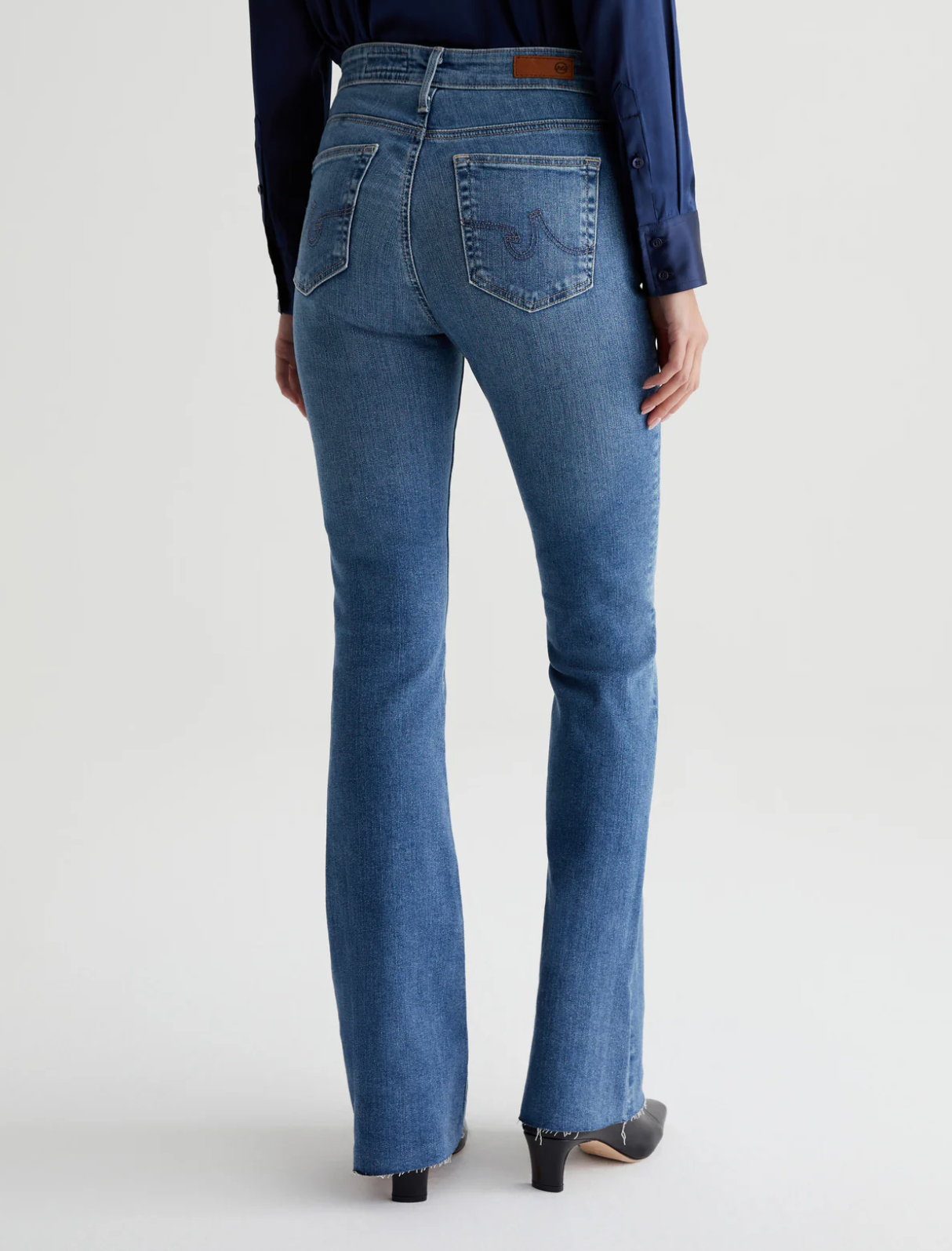 model wearing ag jeans farrah boot cut jean in montecito blue, shown from the rear