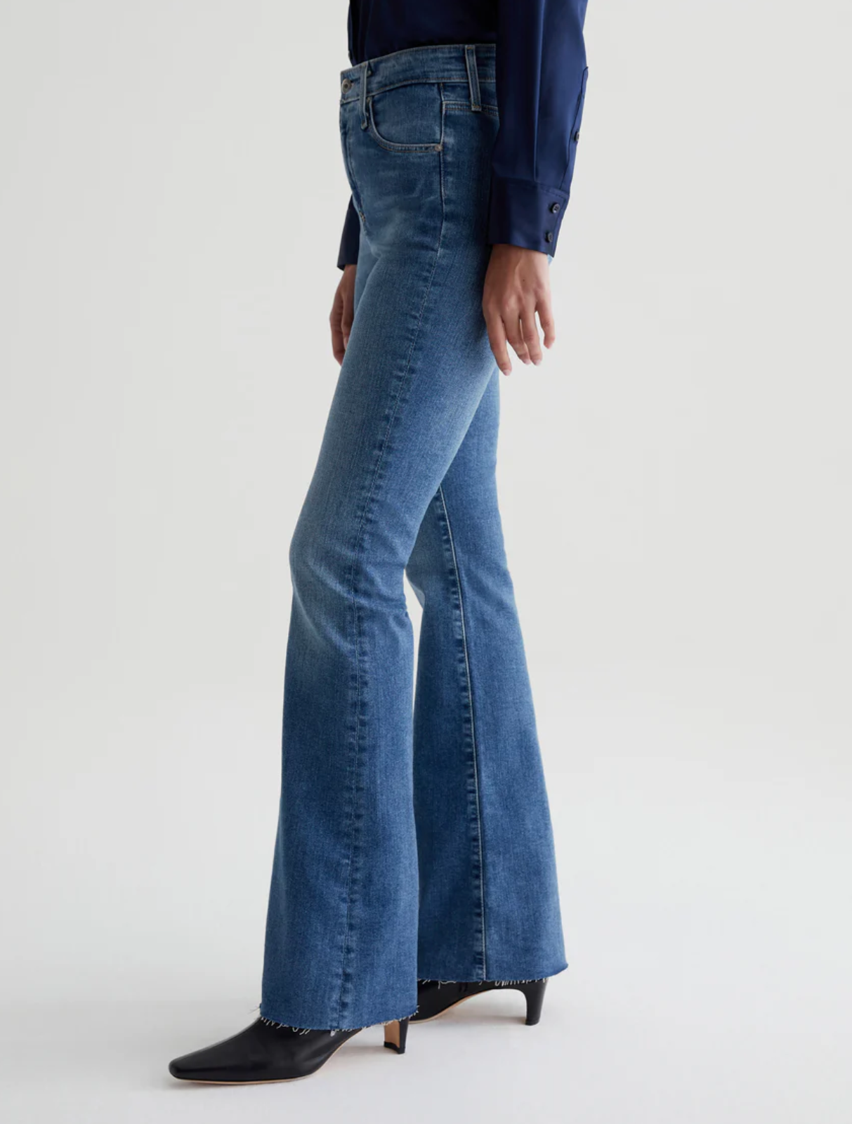 model wearing ag jeans farrah boot cut jean in montecito blue, shown from the opposite side