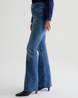 model wearing ag jeans farrah boot cut jean in montecito blue, shown from the opposite side