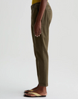 model facing left wearing caden tailored trouser in sulfur shady moss green, shown from the waist down