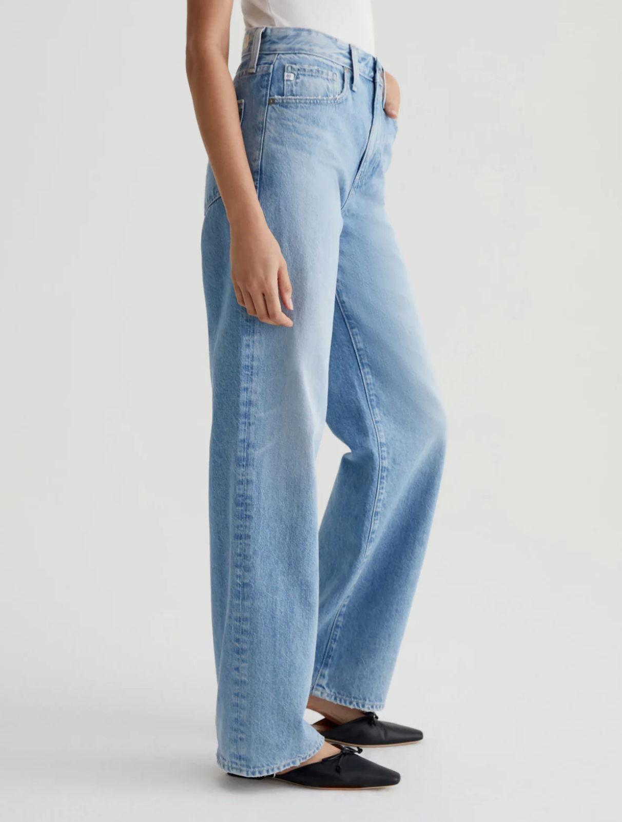 model wearing ag jeans kora high rise wide leg jean in recall blue, shown from the side