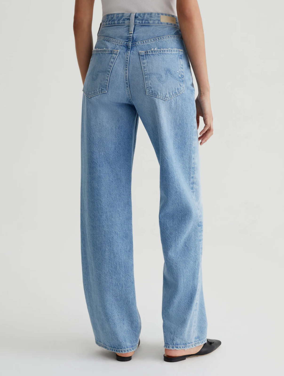 model wearing ag jeans kora high rise wide leg jean in recall blue, shown from the rear